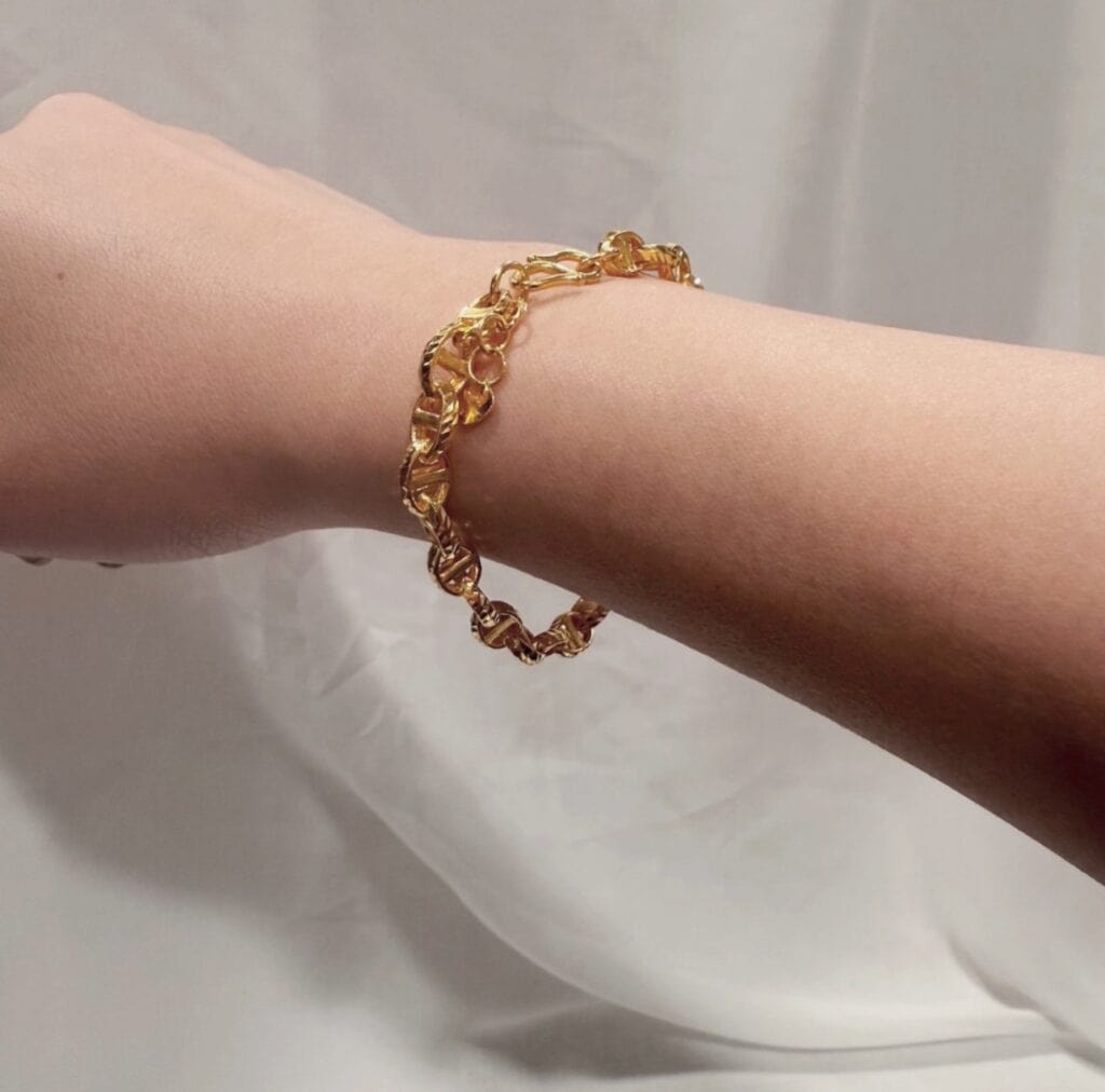 手腕配戴金色扭轉鏈條手鍊示範，展示實際佩戴效果。