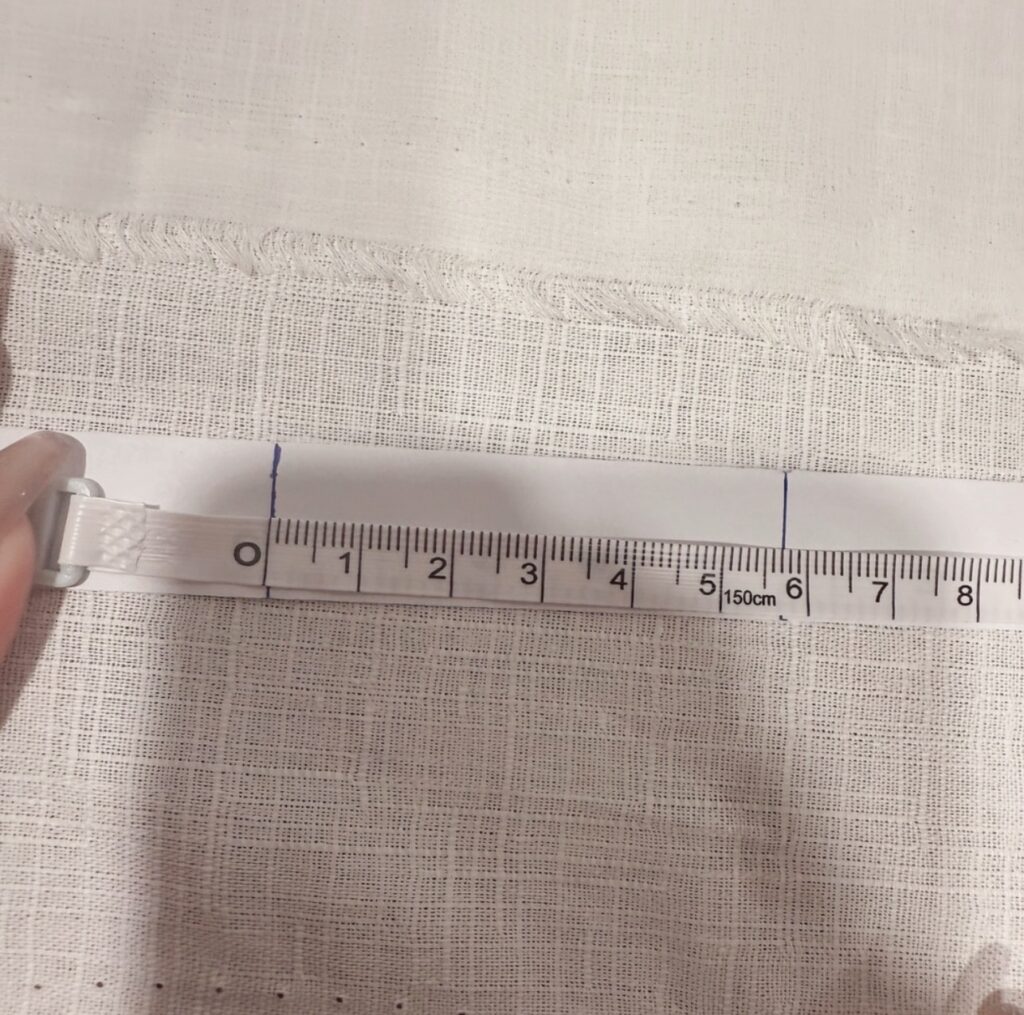 將標記過的紙條平放，用捲尺測量紙條長度以確認戒圍尺寸。