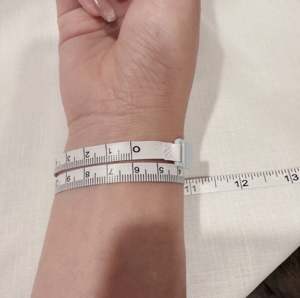 使用捲尺繞在手腕上測量手圍的示範步驟。