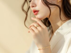 女生佩戴黃金戒指與手鍊，微側身凝視鏡頭，金飾在柔光下閃耀。